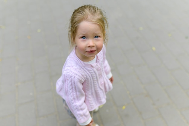 Little girl 2 years old looks at the camera and smiles Closeup shot from above