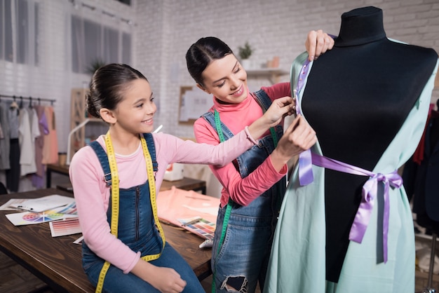 A little girl and an adult woman trying on clothes