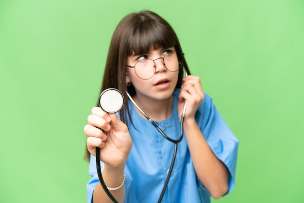 Little girl as a surgeon doctor over isolated chroma key background