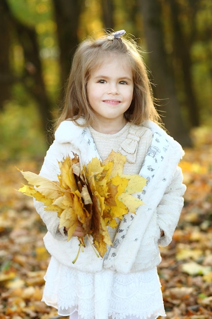 Little girl in autumn forest