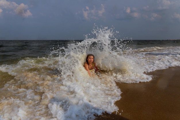 Little girl bathes in waves