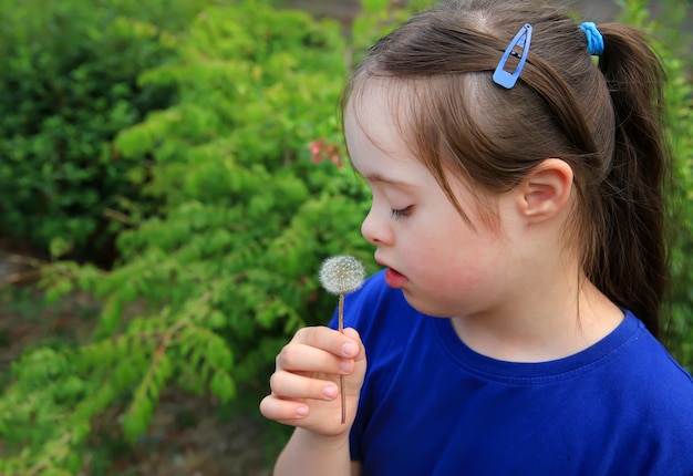 Little girl blowing dandelion