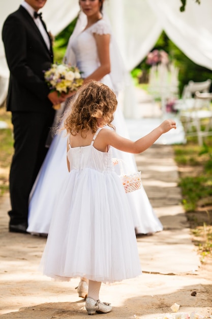 The little girl and brides at the outdoor ceremony