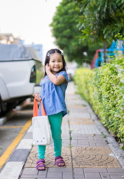 Little girl carrying cloth bag to prepare to shopping