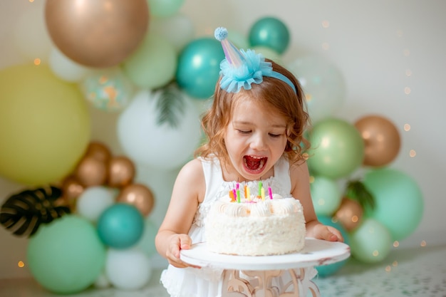 a little girl celebrates her birthday and tries a cake