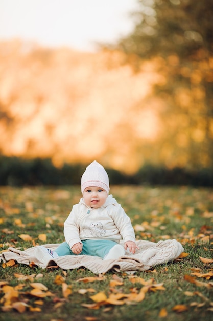 A little girl child in the autumn park smiles spends time Beautiful autumn background