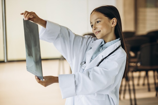 Little girl child doctor looking at xray