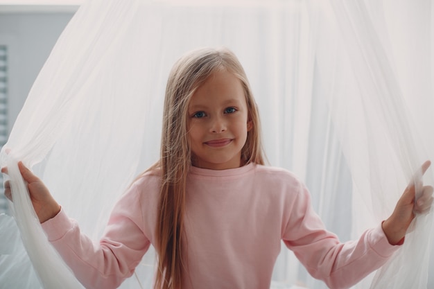 Little girl child in pink clothes portrait at home.