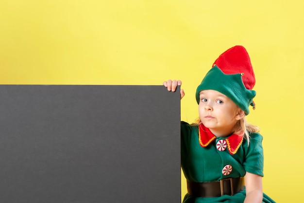 Little girl in a Christmas elf costume with a pensive face.