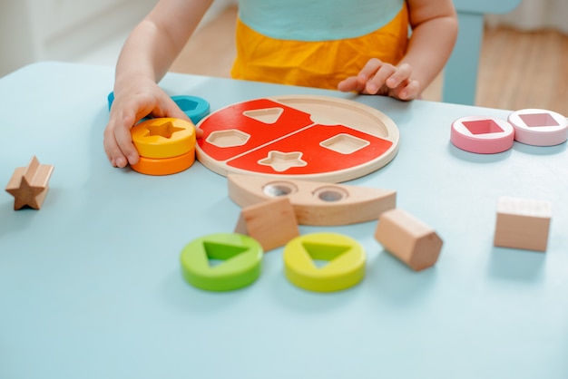 Little girl collects wooden multi-colored sorter Safe natural wooden kids toys