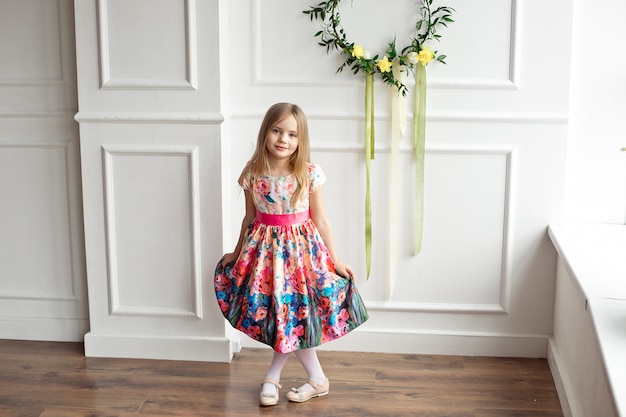 little girl in colorful dress posing indoor