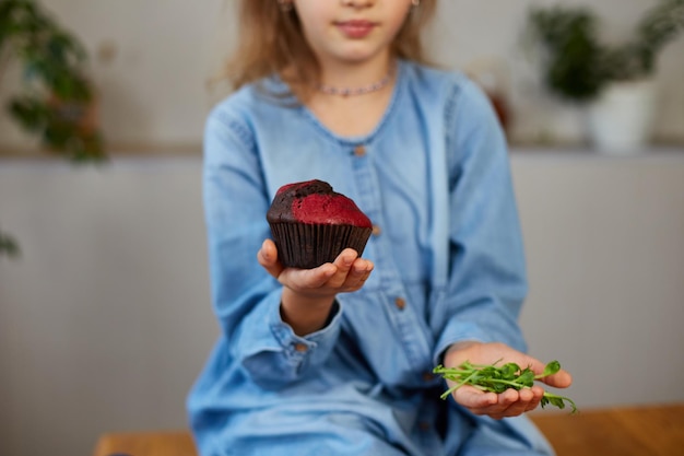 Little girl comparing food choosing sweet cake against microgreen UnHealthy habit concept of malnutrition