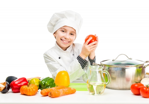 Little girl-cook by table with vegetables