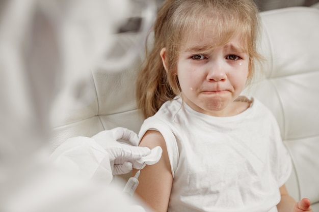 Little girl cries her hurt and scared. injection during illness. Vaccination.