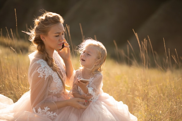 A little girl cries while her mom is talking on the phone