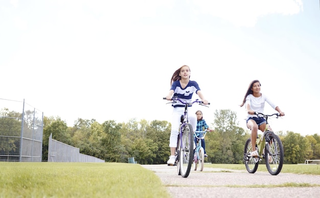 A little girl cycling on the road with her friends