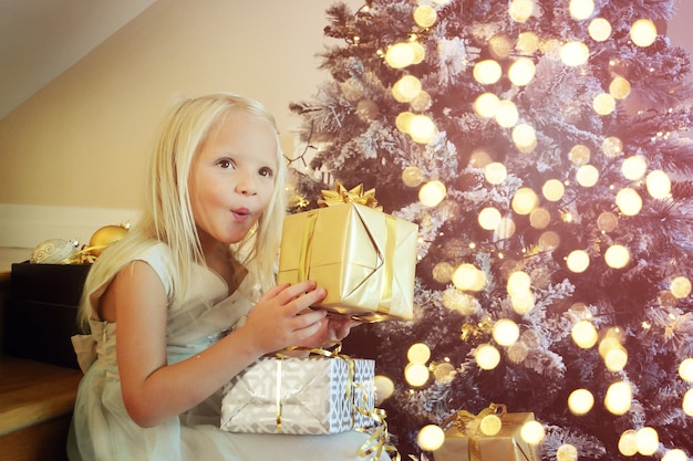 Little girl decorating Christmas tree at home