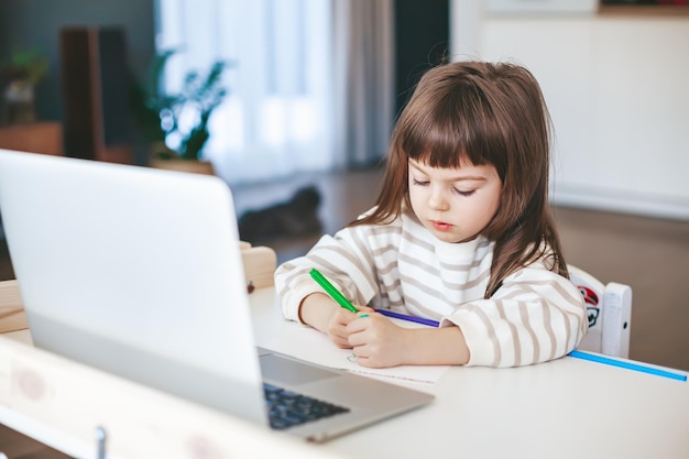 Little girl drawing on the online art lesson