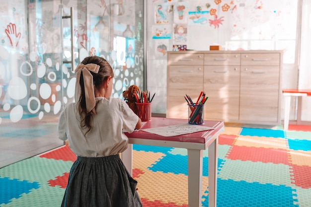 Little girl drawing with color pen in paper on table at playroom, Baby healthy and preschool concept