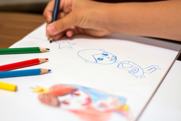 Little girl drawing with wooden color pencils