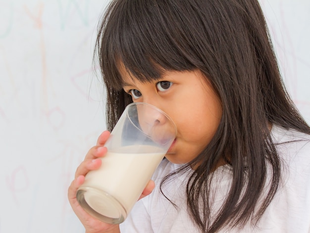 little girl drinking glass of milk