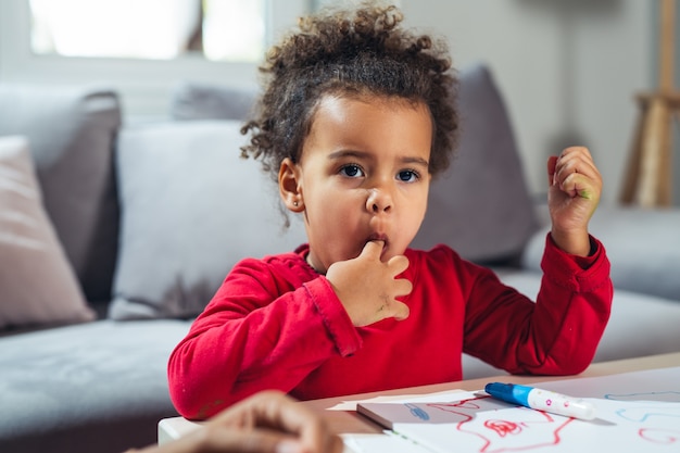 Little girl eating candies at home 