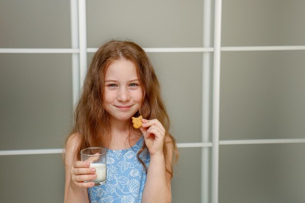 little girl eating cookies with milk