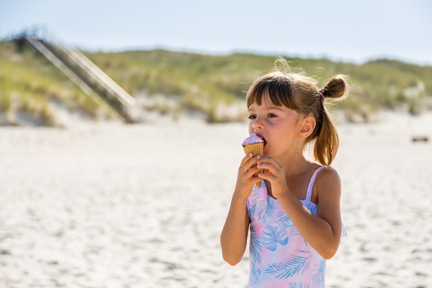 Little girl eating icecream on a beach