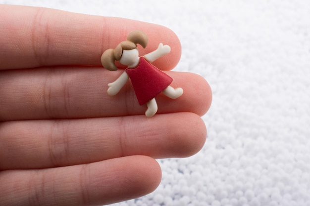 Little girl figurine in hand on white background