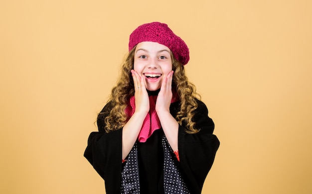 Little girl in french beret Fall trend beauty autumn fashion Happy childhood cheerful child in positive mood parisian kid in autumn clothes little girl in stylish coat and red scarf Autumn joy