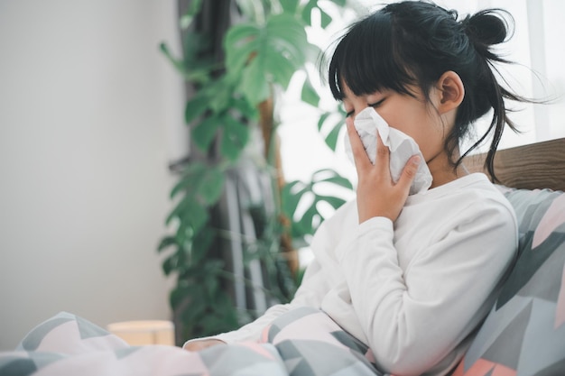 Little girl gets cold and blows her nose at home