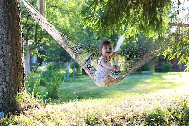 Photo little girl in hammock nature summer