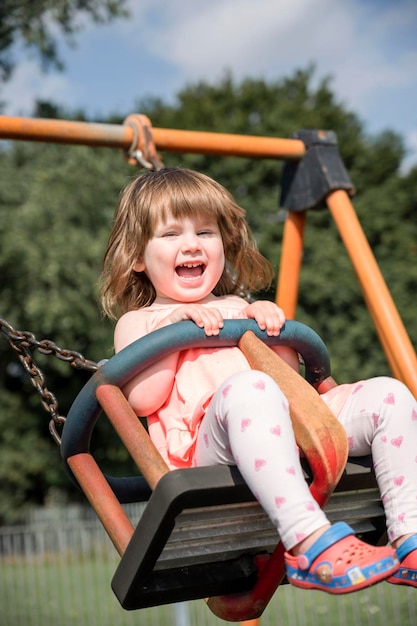 Little girl having fun on a swing outdoor toddler girl happy kid