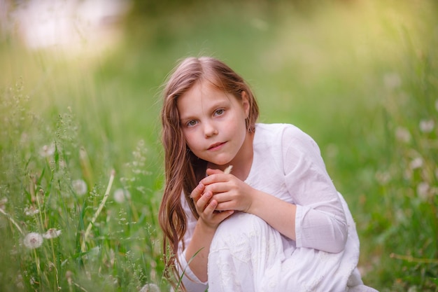 Little girl holding chicken hands playing on the grass