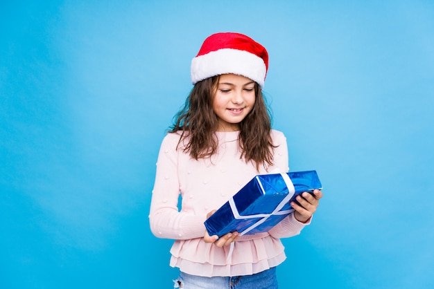 Little girl holding a gift celebrating christmas day