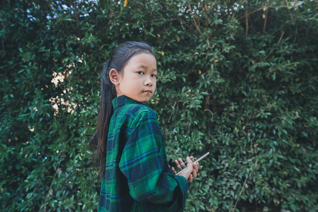 little girl holding phone alone .outdoor study. 