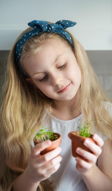 Little girl holding a pot of seedlings