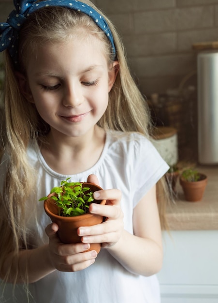 Little girl holding a pot of seedlings