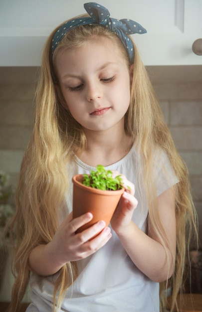 Little girl holding a pot of seedlings