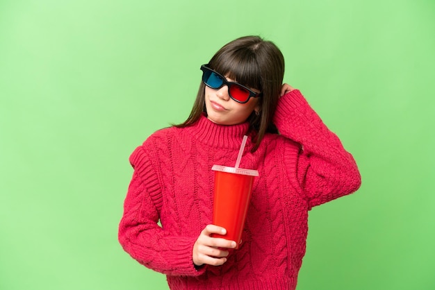 Little girl holding soda over isolated chroma key background having doubts