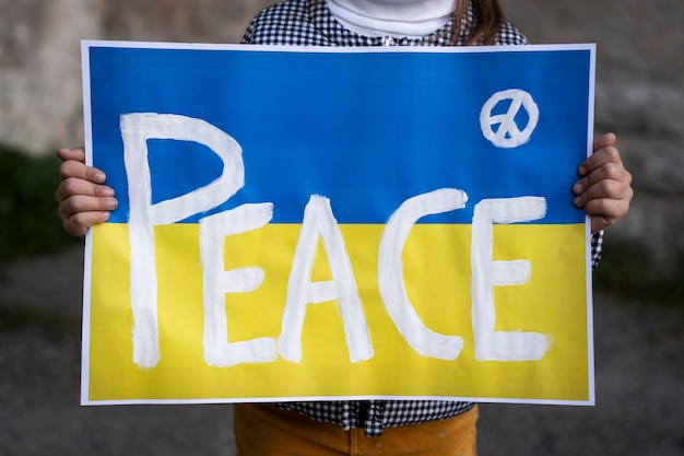 Little girl holding ukrainian flag Peace and no war concept Focus on banner