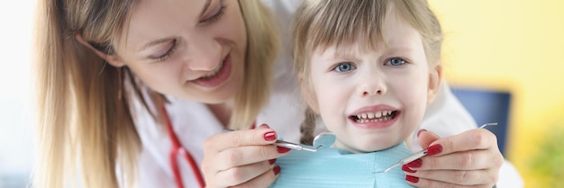 Little girl is afraid of dentist doctor children fears during dental treatment concept