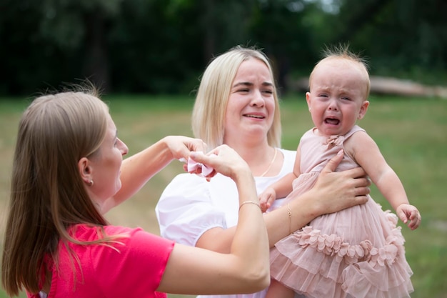 A little girl is crying in her mother's arms