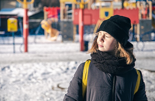 A little girl is heated in the sun in cold winter weather