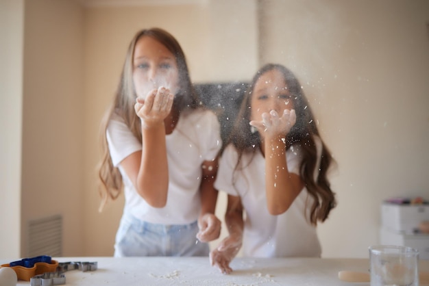 Little girl is helping to bake in a messy kitchen