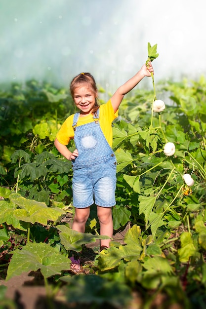 A little girl is holding a branch with white pumpkins