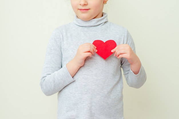 Little girl is holding red little heart