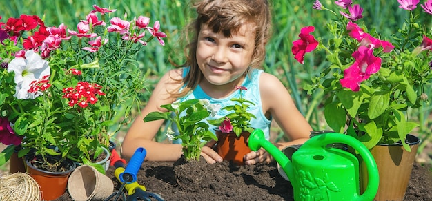 A little girl is planting flowers.   