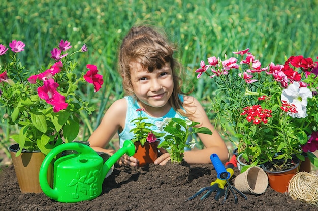 A little girl is planting flowers.