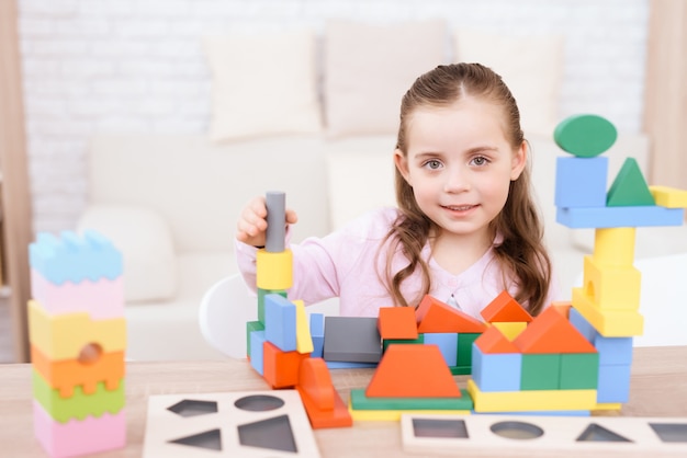 A little girl is playing with colorful cubes.